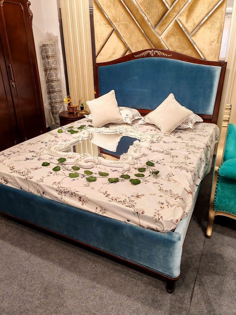 Bed with a velvet-covered cushioned headboard and base