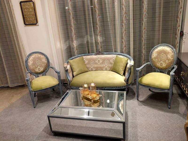 Sitting room with a two-seat sofa, armchairs and a mirrored coffee table