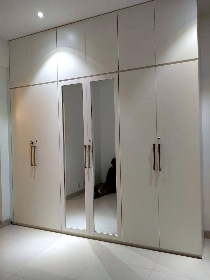 White floor-to-ceiling wardrobes with mirrored doors